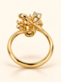 Gold floral ring with sparkling clear stones and elegant leaf detailing on a warm ivory background, Baarah Jewels.