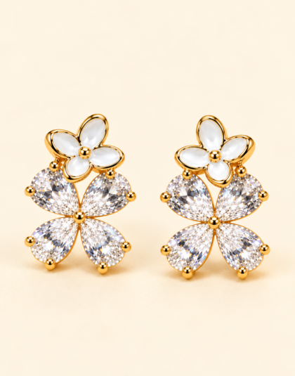 Gold-tone floral stud earrings with white enamel flowers and sparkling clear crystal petals.