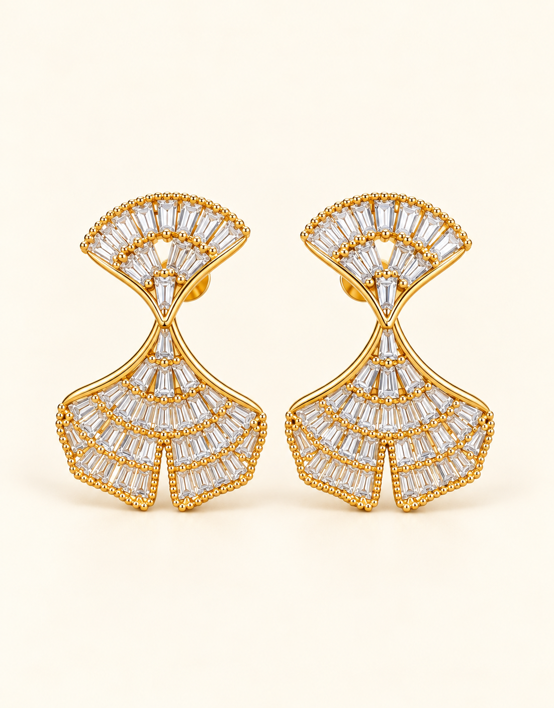 Gold-tone fan-shaped hanging earrings with sparkling clear baguette-cut stones and intricate detailing.