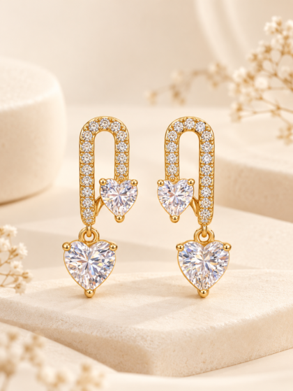 Gold-tone heart drop earrings with sparkling clear stones, featuring a crystal-studded U-shaped design and two heart-shaped gems.